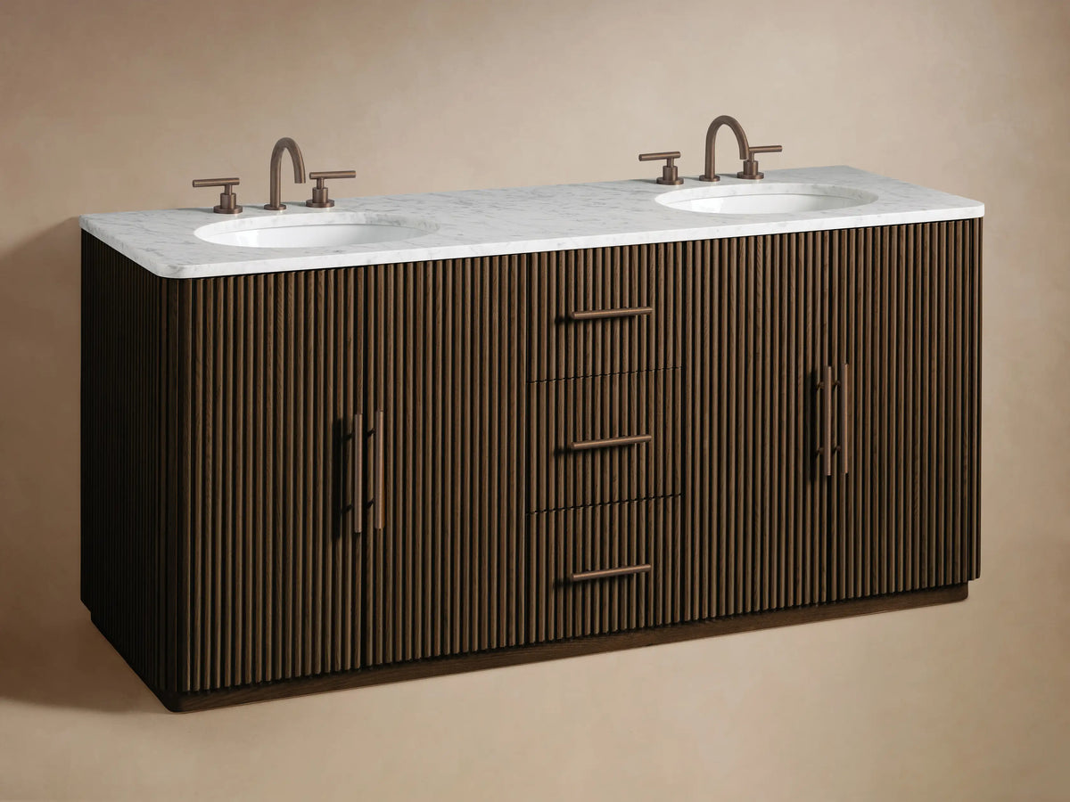Close-up of Finnley Double Vanity's open dark wood cabinet. Fluted door, dark handle. Inside: natural sponge in white bowl, stacked white towels.