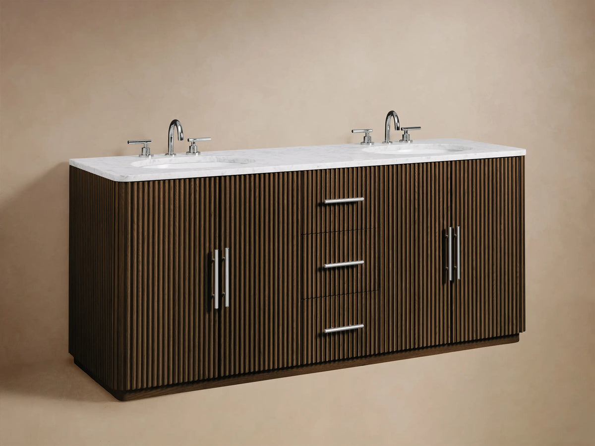 Finnley Double Vanity: Partially open dark reeded cabinet door with polished handle, revealing white folded towels and cosmetic bottles inside.