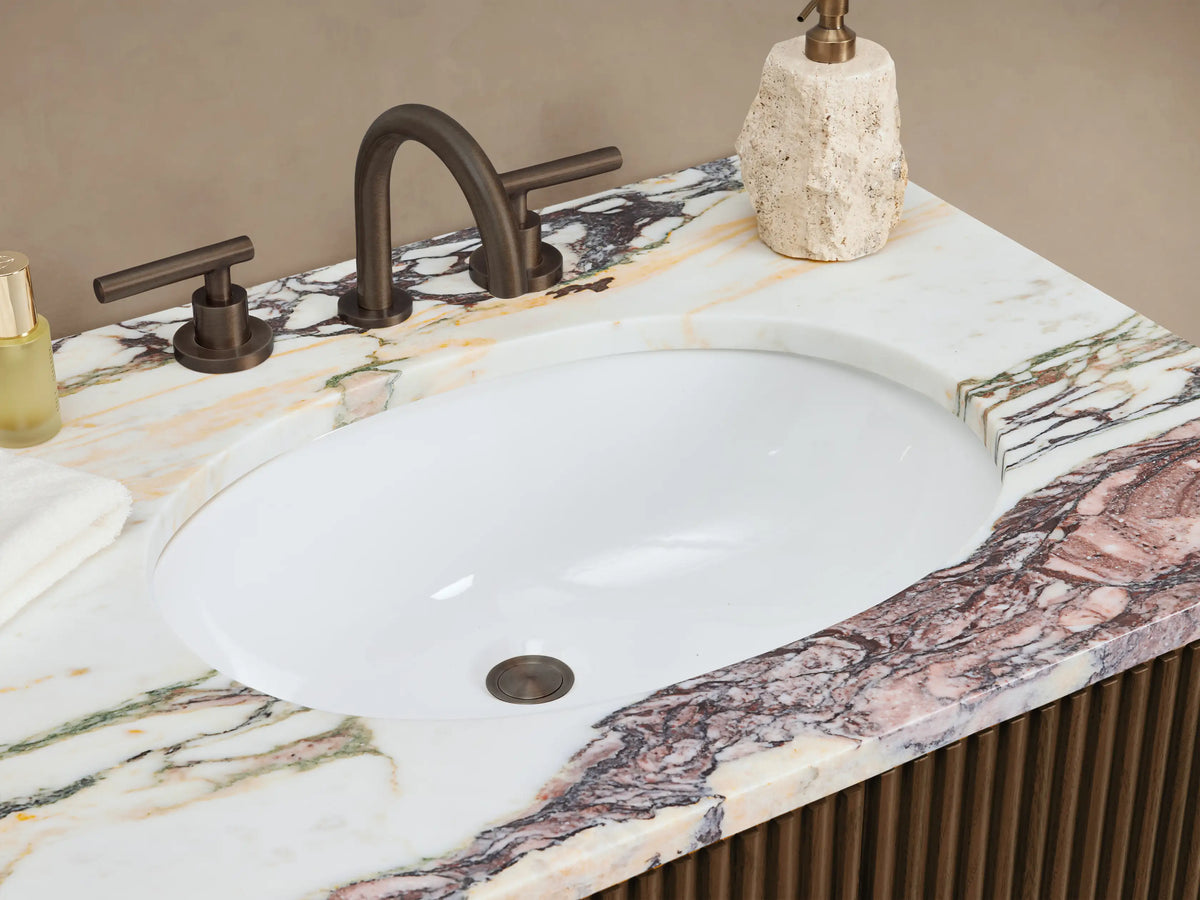 Finnley Double Vanity: dark wood, fluted front, veined marble top, two double doors, three central drawers, bronze pulls.