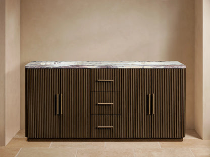 Finnley Double Vanity, dark fluted oak with white veined marble top, two brass faucets, three drawers, one cabinet open showing towels.