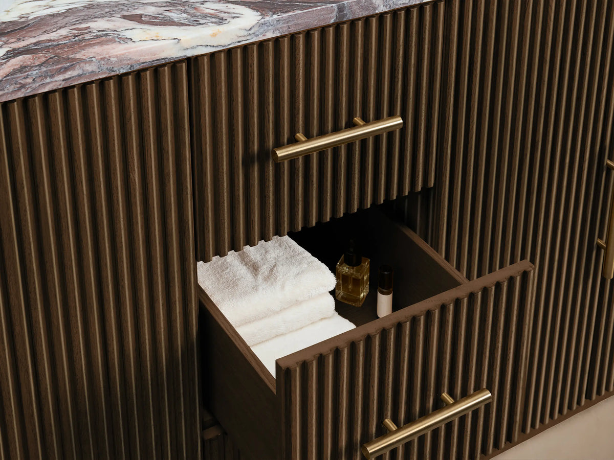 Close-up of Finnley Vanity, white oval undermount sink, multi-colored marble top with gold, burgundy veins, and faucet holes.