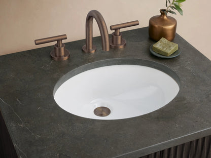 Finnley Powder Vanity: dark fluted wood cabinet, dark stone top with oval sink, and bronze pulls, against a light wall & tiled floor.