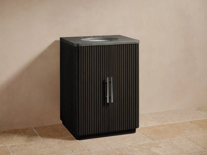 Finnley Powder Vanity with dark vertical slatted wood, oval sink with chrome faucet, on beige tiled floor against a light wall.