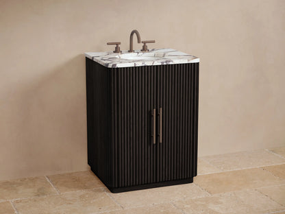 Close-up of a partially open dark wood Finnley Powder Vanity cabinet with ribbed door, showing a shelf with a jar, bottle, and folded towels inside.
