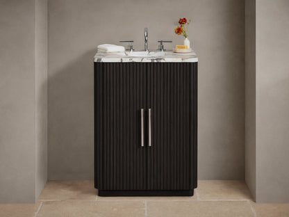 Finnley Powder Vanity with dark brown fluted doors, white veined marble top, chrome faucet & accessories in a neutral bathroom.