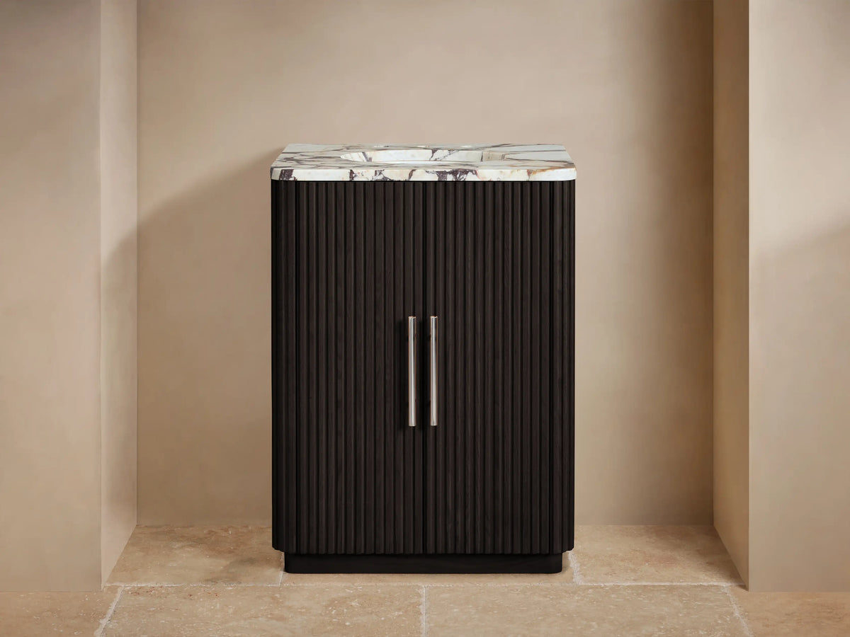 Finnley Powder Vanity with dark brown fluted doors, white veined marble top, chrome faucet & accessories in a neutral bathroom.