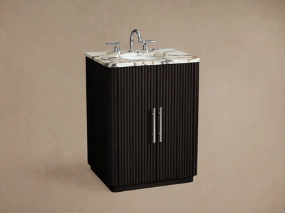 Front view of Finnley Powder Vanity. Dark fluted wood cabinet, veined white marble top, 2 polished nickel pulls. On stone floor.