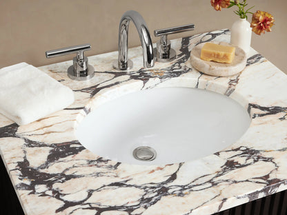Finnley Powder Vanity: Dark fluted cabinet with white Carrara marble top, oval sink, and polished nickel handles.