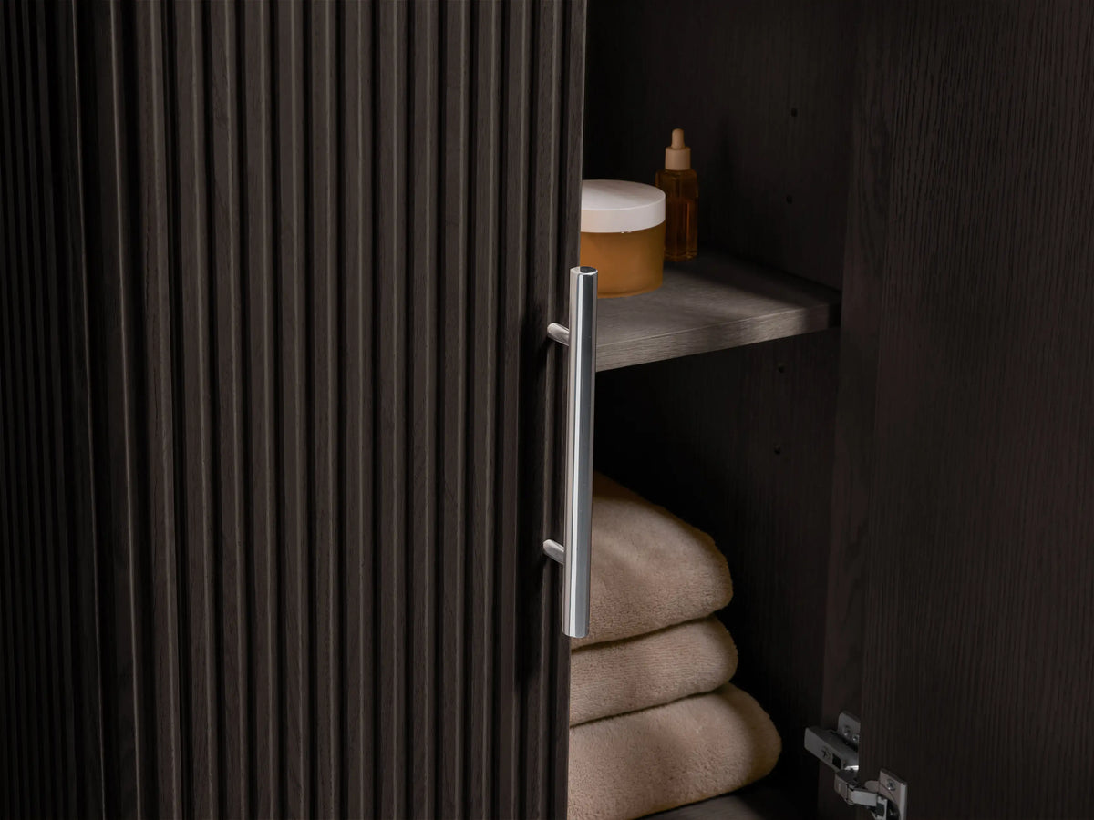 Angled close-up of Finnley Powder Vanity's oval white sink set in a cream, black, and gold veined marble countertop.