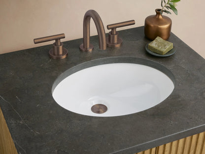 Finnley Powder Vanity. Front view of fluted light wood cabinet, dark handles, dark gray stone countertop with white oval sink, against a light wall.