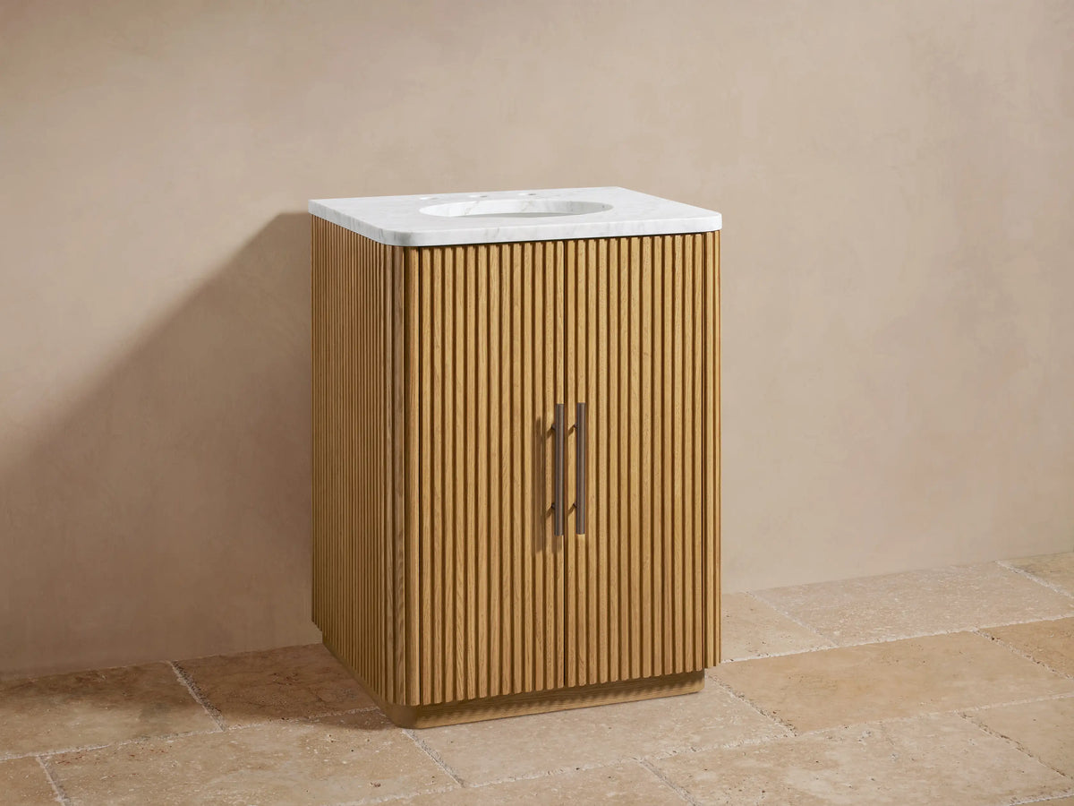 Finnley Powder Vanity: Light oak wood cabinet with vertical fluting, white marble top, oval sink, and dark bronze faucet.