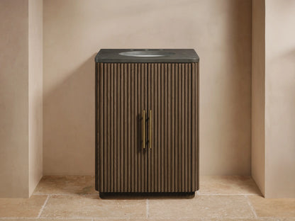 Finnley Powder Vanity: Dark brown reeded oak cabinet with bluestone top, white oval sink, gold faucet, and brass bar handles.