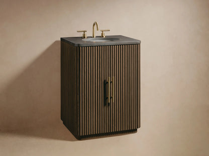 Close-up of Finnley Powder Vanity's fluted brown oak door with brass handle, slightly open, revealing white towels and beauty products.