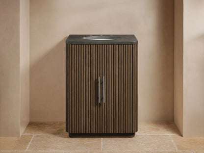 Finnley Powder Vanity, dark fluted wood cabinet with two doors, dark stone top, white oval sink, chrome faucet & handles.