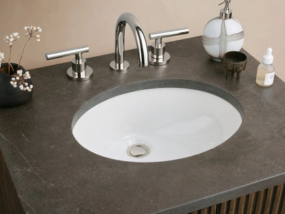 Finnley Powder Vanity with dark fluted wood cabinet, dark stone countertop, oval sink, and silver handles.