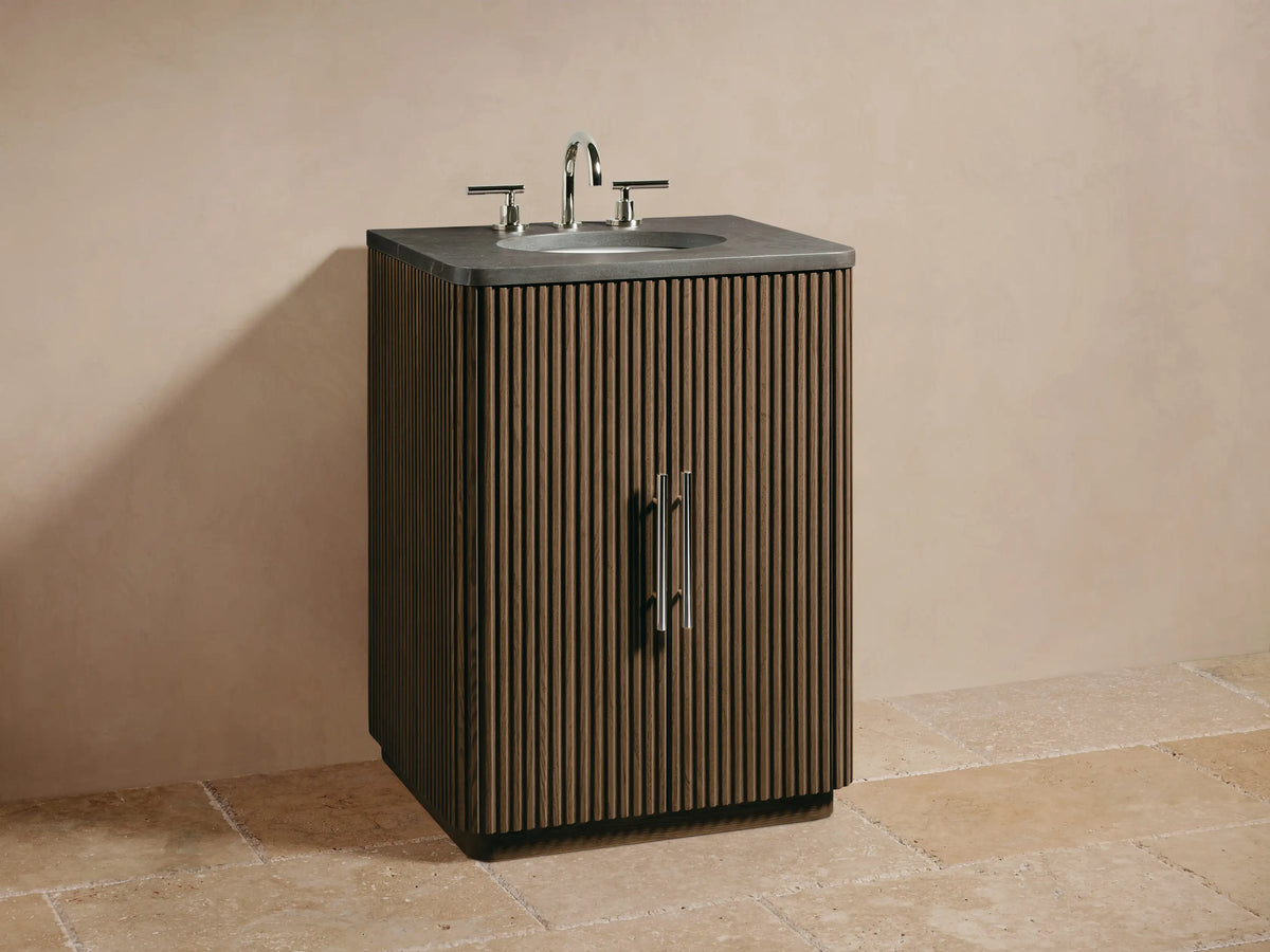 Close-up of Finnley Powder Vanity's fluted oak wood door, partially open to reveal shelves with cream jar, amber bottle, and towels.
