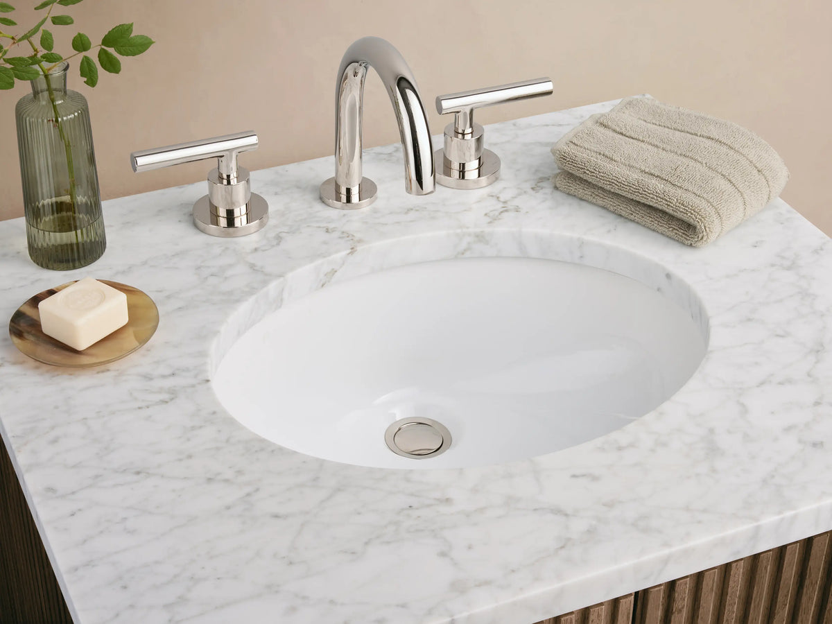 Dark brown fluted wood Finnley Powder Vanity with white marble top, integrated oval sink, and silver handles.