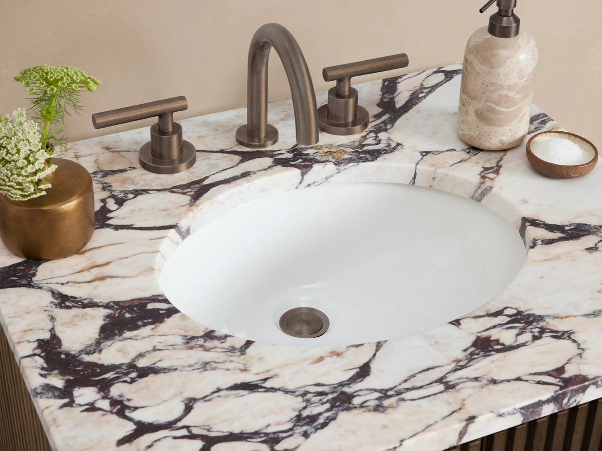 Dark brown fluted Finnley Powder Vanity with white and gray veined marble top, centered in a beige room with light tiled floor.
