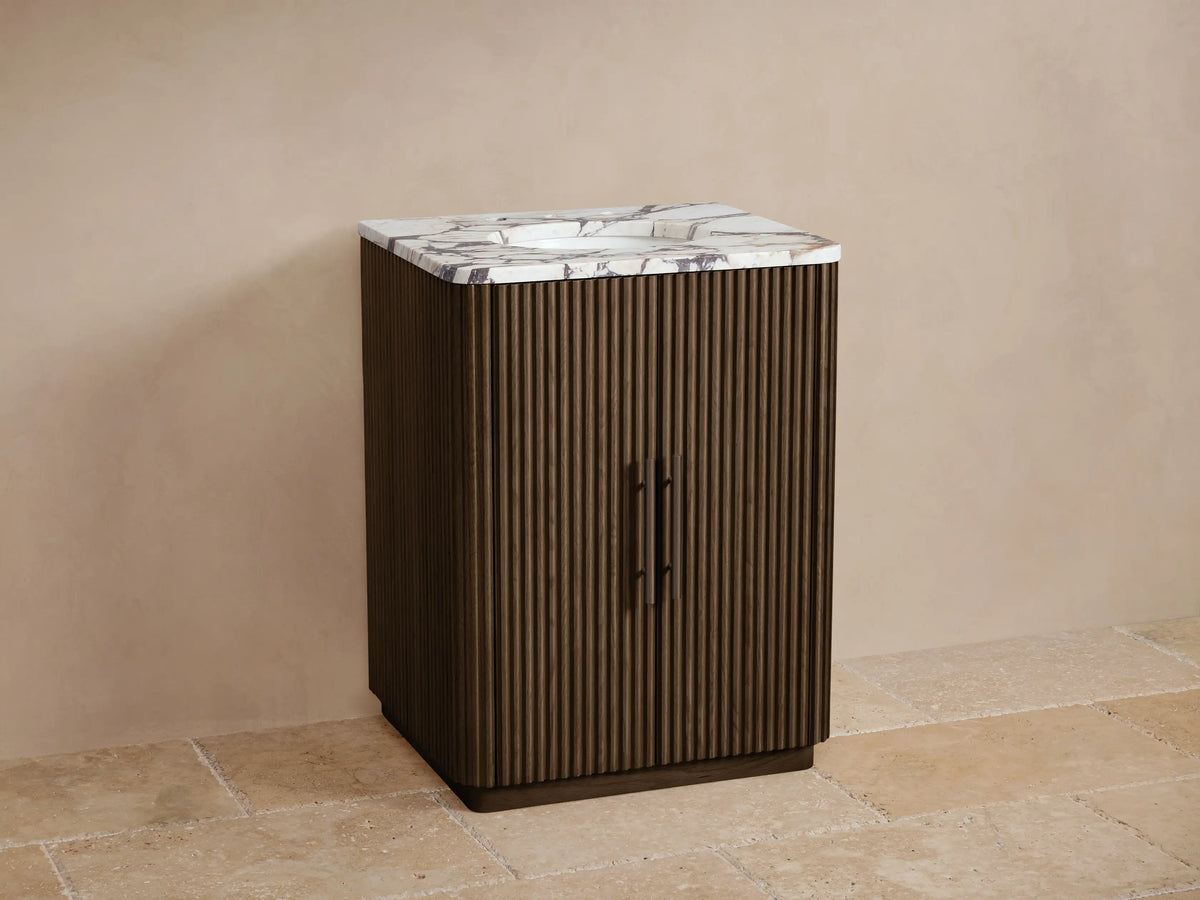 Finnley Powder Vanity: Dark brown fluted cabinet with white marble top, integrated sink, and dark bronze faucet.