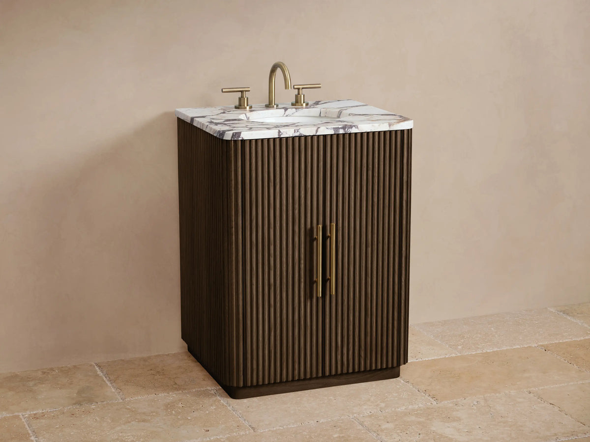 Finnley Powder Vanity, dark fluted oak wood with a veined marble top & antique brass pulls, full front view in a neutral room.