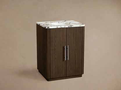 Finnley Powder Vanity: Dark brown ribbed wood vanity with a white marble top, silver handles, against a beige wall.