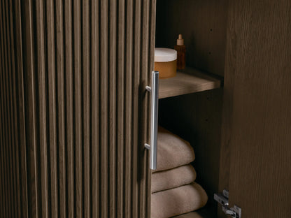 Detailed view of the Finnley Powder Vanity's white oval sink and patterned marble top with cream, dark brown, and gold veins, faucet holes.