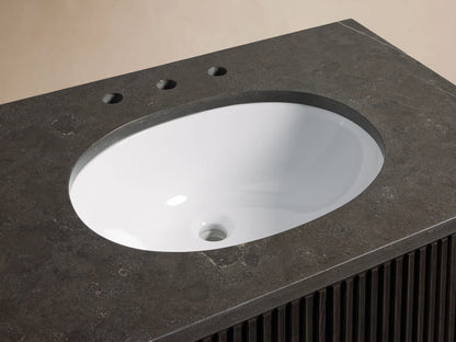 Finnley Single Vanity with dark stone top, oval white undermount sink, bronze faucet, and accessories on counter.