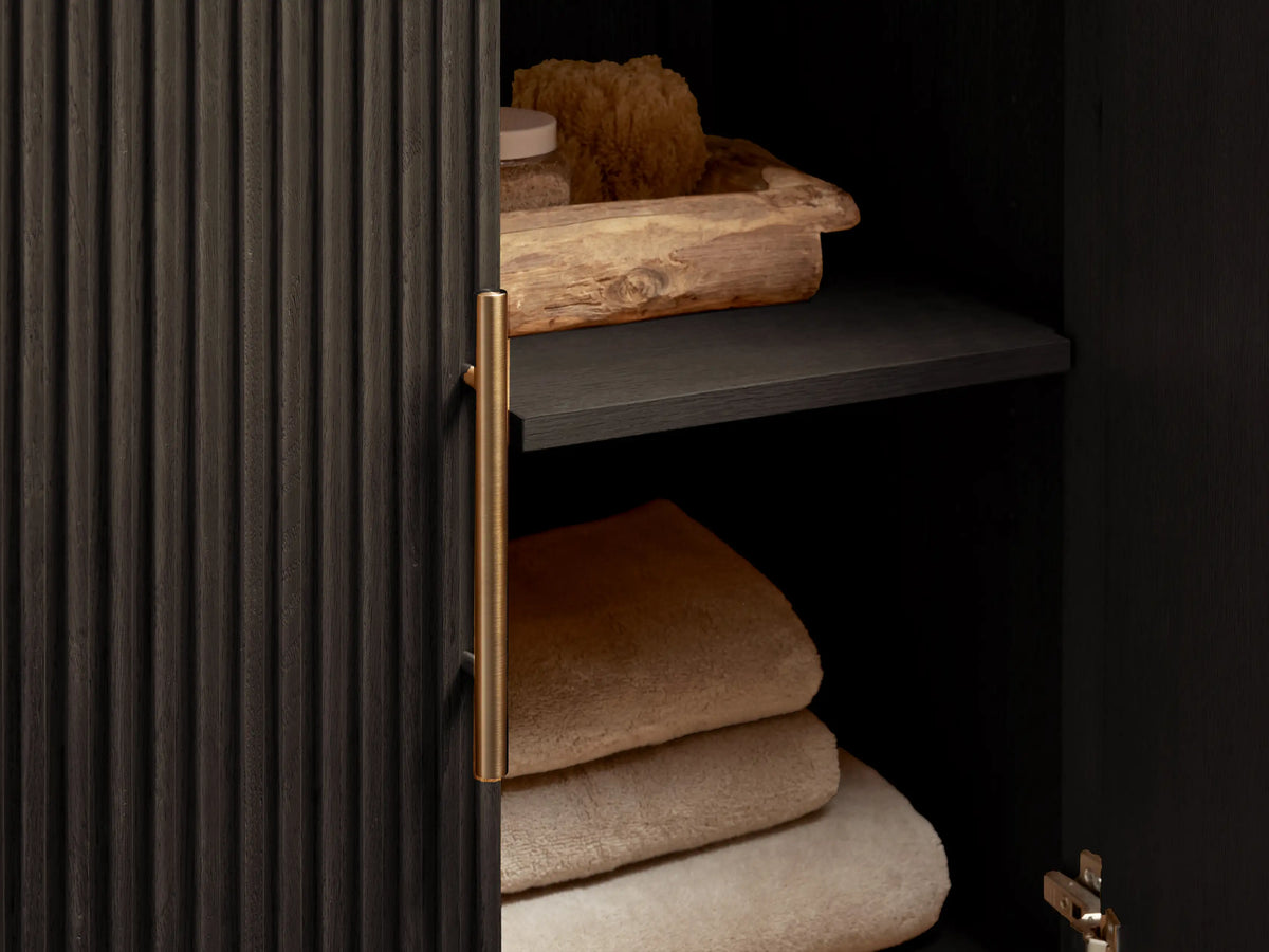 Finnley Single Vanity with vertical slatted oak wood finish, black stone top, and oval ceramic sink; dual door with polished hardware.