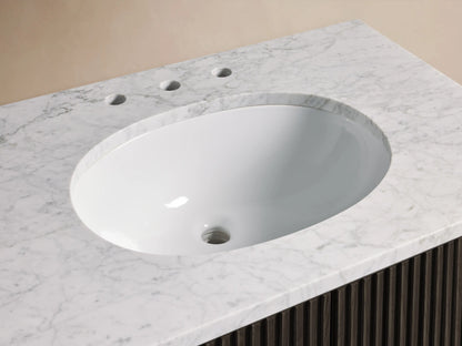 Finnley Single Vanity: Close-up of white marble top with oval undermount sink, dark bronze widespread faucet, and slatted dark wood base.