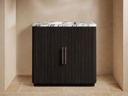 Finnley Single Vanity with a white marble top, gray veining, dark fluted wood cabinet, and a dark metal faucet in a modern bathroom.