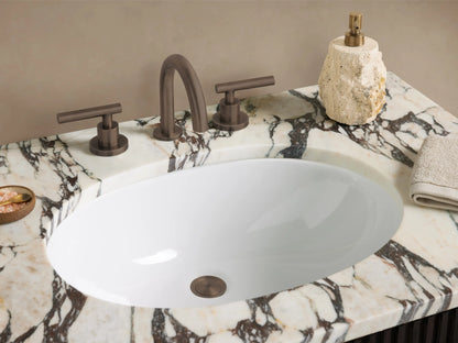 Finnley Single Vanity: dark fluted cabinet, white marble top with grey veins, dark handles, against a beige wall, stone floor.