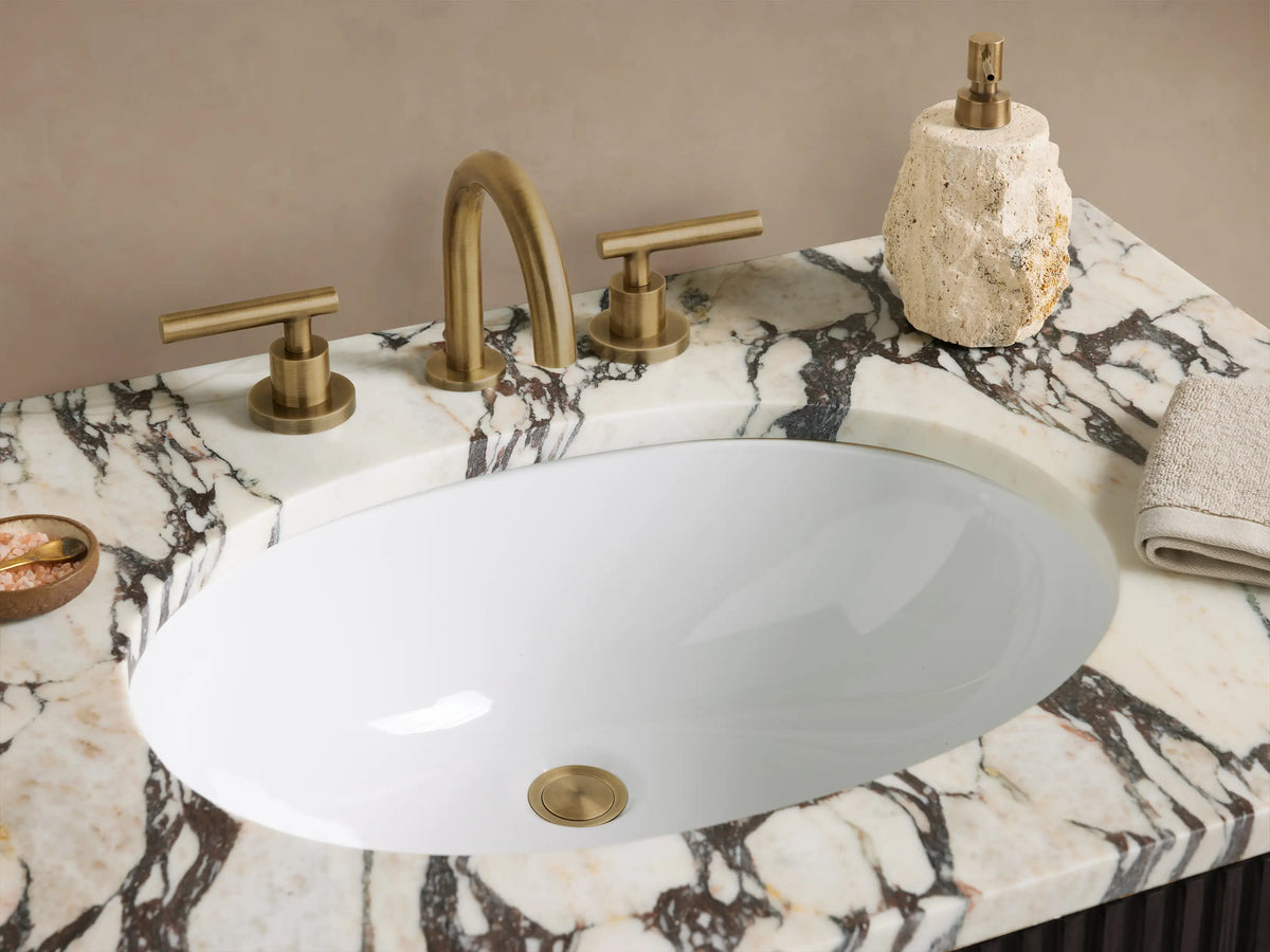 Finnley Single Vanity: dark, ribbed wood cabinet, white marble top with gray veining, gold vertical handles, front view.