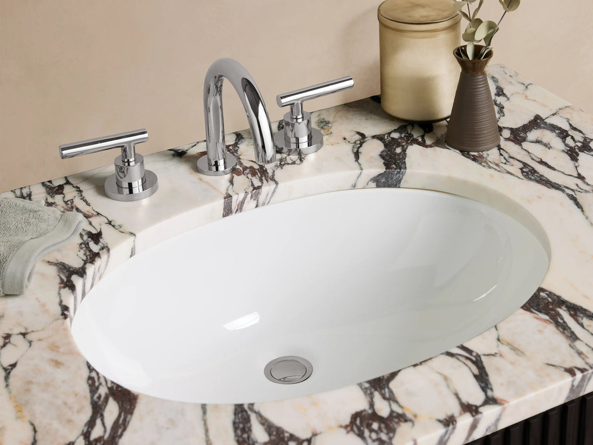 Finnley Single Vanity with dark fluted cabinet, white marble top with gray veins, polished nickel handles, on stone tile floor.