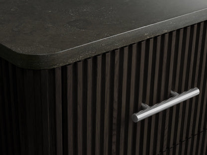 Close-up of Finnley Short Bath Cabinet's open dark reeded wood drawer, holding a stack of white towels, with a silver pull handle.