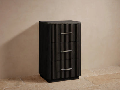 Close-up of Finnley Short Bath Cabinet's dark gray stone top with rounded corner over dark brown ribbed wood and silver handle.
