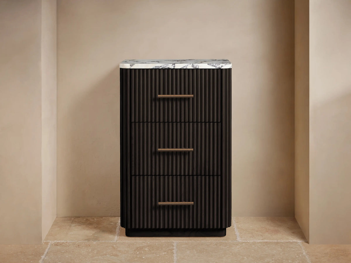 Dark fluted Finnley Short Bath Cabinet with white Carrara marble top and 3 drawers, featuring antique brass pulls.