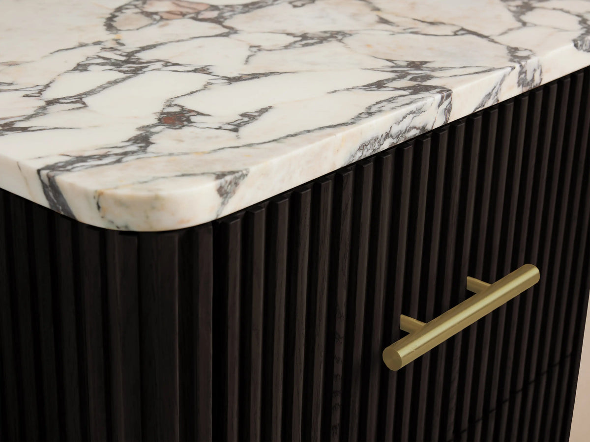 Finnley Short Bath Cabinet's open dark fluted drawer with brass pull, containing two neatly folded beige towels.