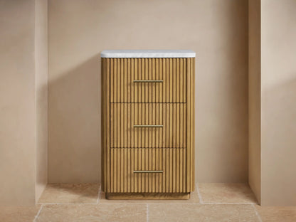 Finnley Short Etagere showcasing a partially opened oak wood drawer with vertical grooves, holding folded white towels and polished metal handles.