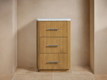 Finnley Short Etagere with a stone top, vertical slatted wood pattern, three drawers with metallic handles, and decorative items on top.