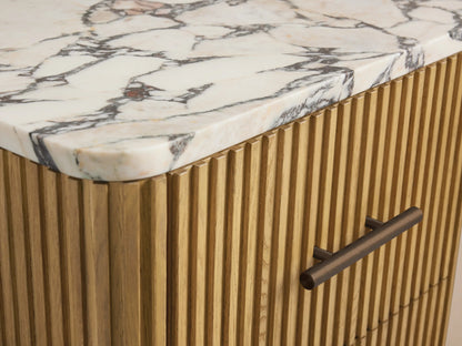 Finnley Short Bath Cabinet in light oak wood with vertical fluting, white Carrara marble top, and 3 drawers with bronze handles.