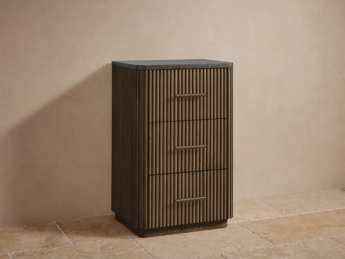 Close-up of Finnley Short Bath Cabinet's open fluted oak drawer with neatly stacked white towels inside and a bronze pull.
