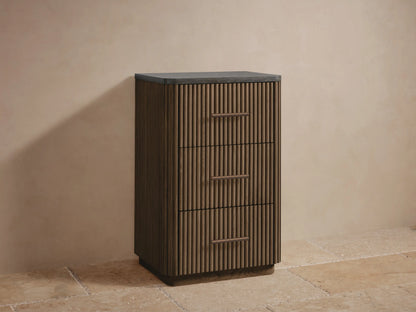 Close-up of Finnley Short Bath Cabinet's open fluted oak drawer with neatly stacked white towels inside and a bronze pull.
