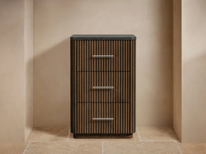 Dark oak Finnley Short Bath Cabinet with vertical fluting, 3 drawers, polished nickel handles & dark stone top. Styled with towels & vase.