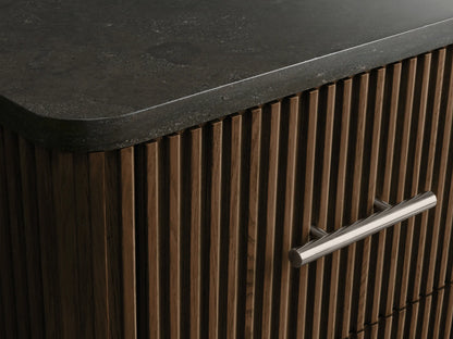 Finnley Short Bath Cabinet: Dark oak wood with vertical fluting, dark grey stone top, 3 drawers, polished nickel handles.