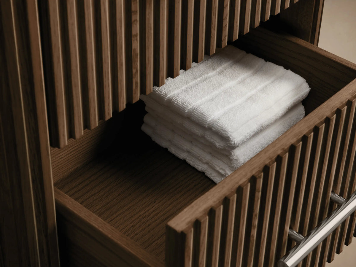 Close-up of Finnley Short Bath Cabinet showing its dark bluestone top and vertical fluted dark oak front with a polished nickel handle.