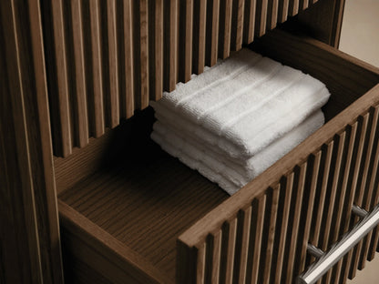 Close-up of Finnley Short Bath Cabinet showing its dark bluestone top and vertical fluted dark oak front with a polished nickel handle.