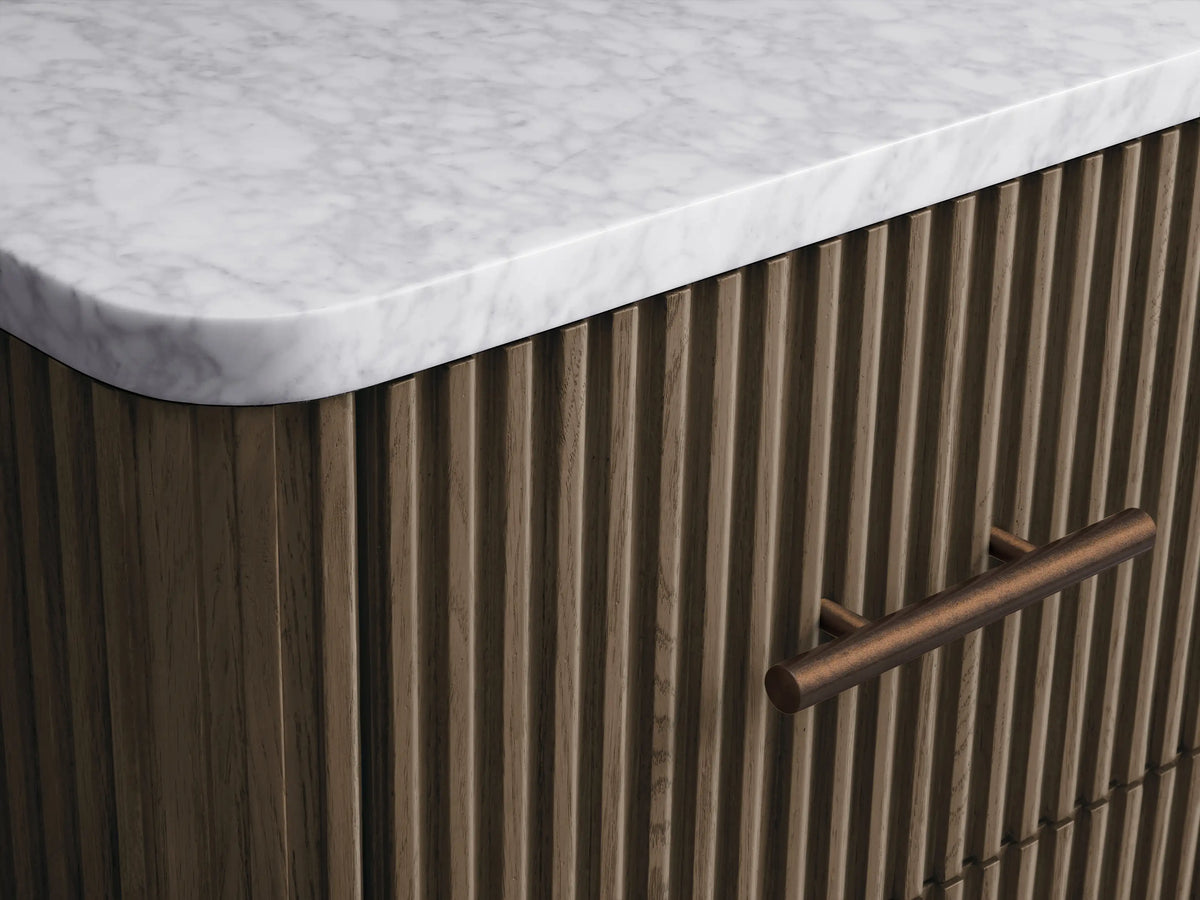 Finnley Short Bath Cabinet: Dark brown fluted wood design with a white marble top, three drawers, and antique brass handles.