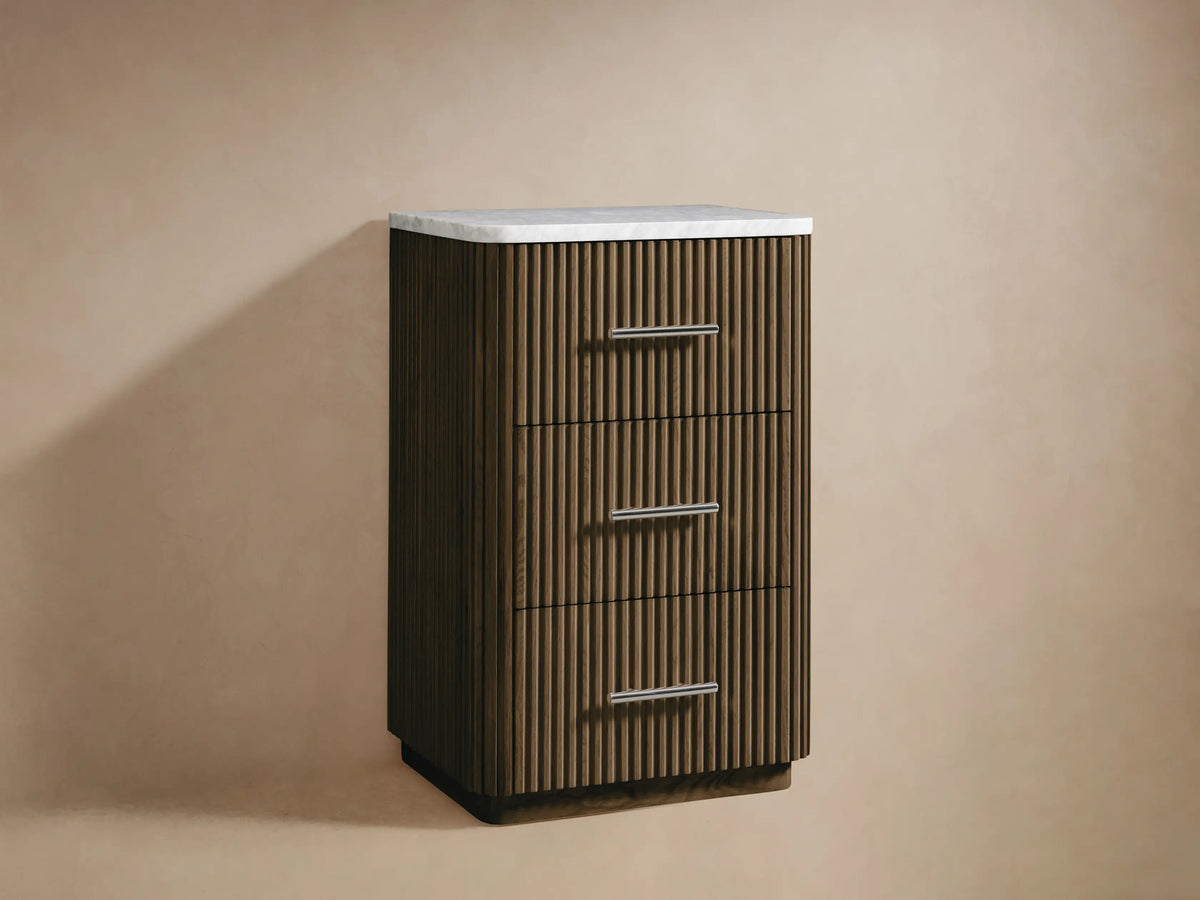 Open drawer of Finnley Short Bath Cabinet. Dark oak wood with ribbed front, holding white towels. Polished nickel pull.