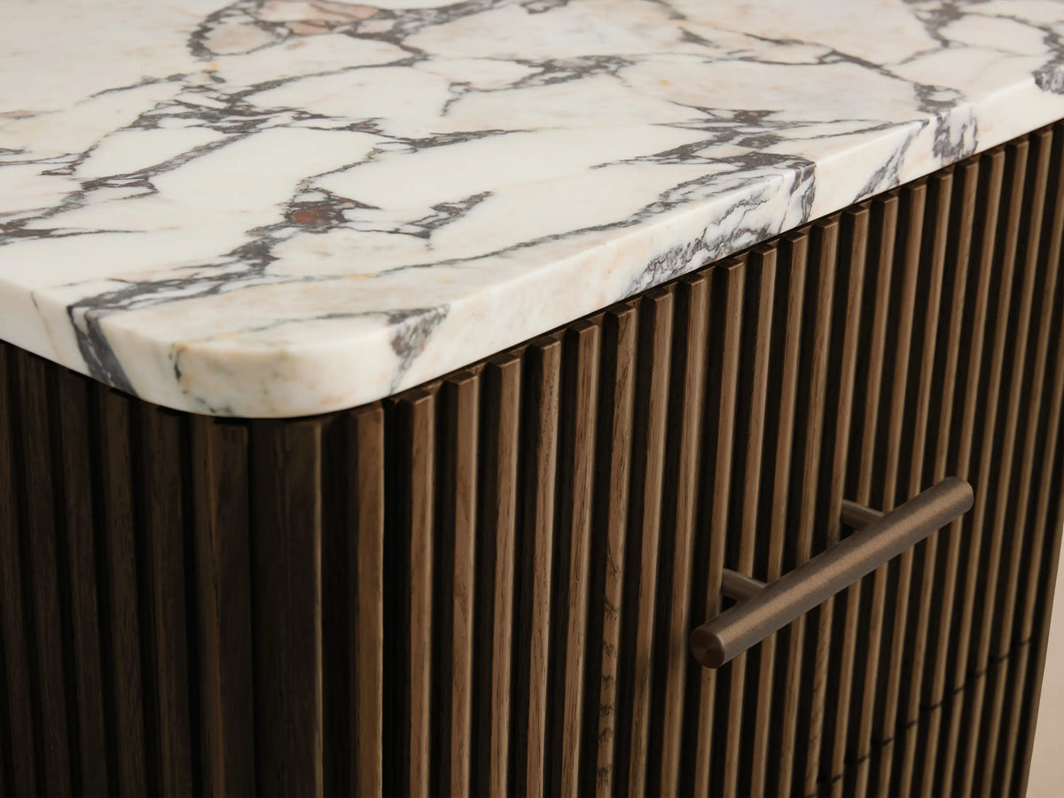 Finnley Short Bath Cabinet: Dark slatted wood, white marble top, 3 drawers with bronze pulls, in a light beige room.