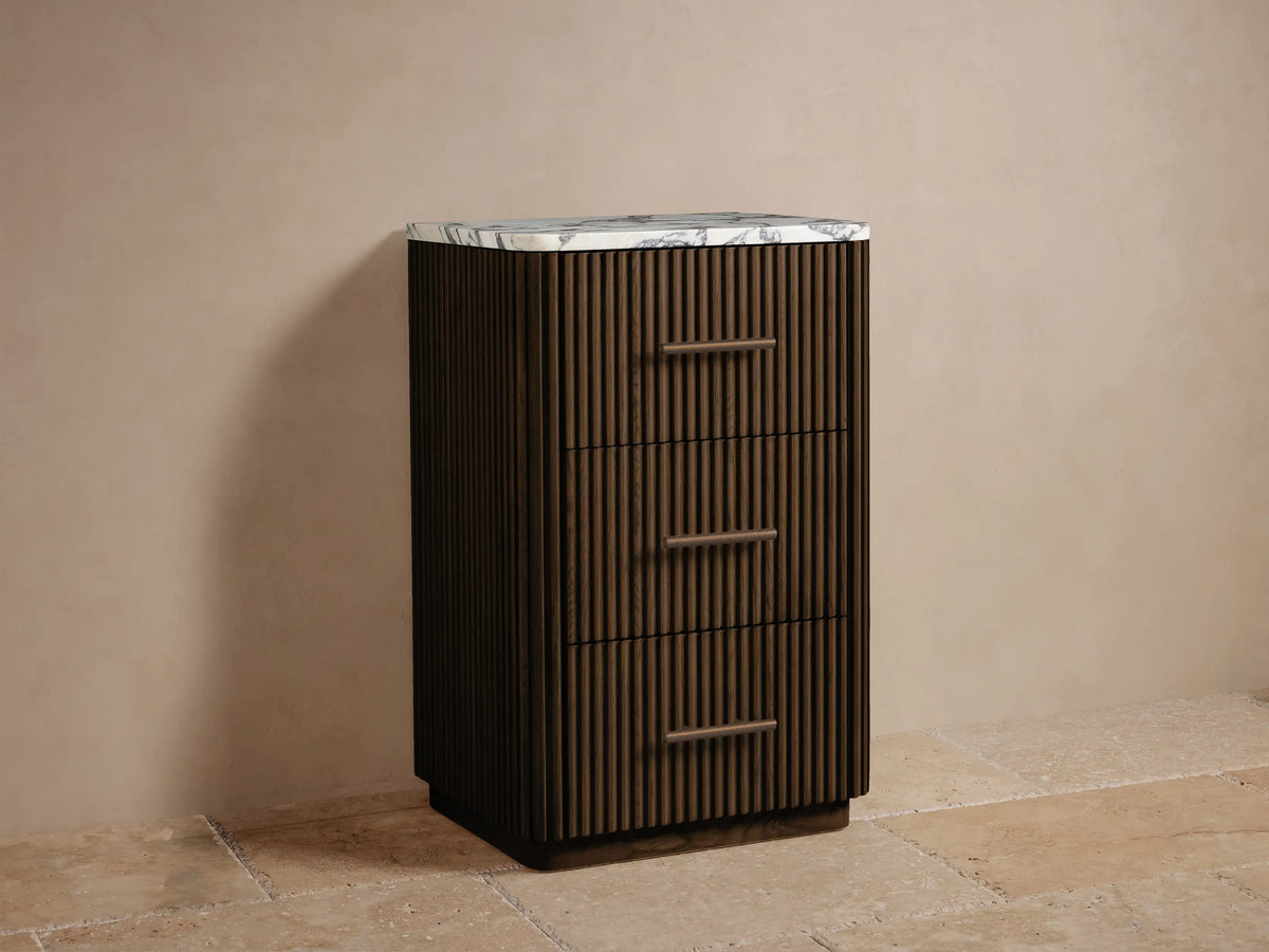 Close-up of Finnley Short Bath Cabinet's open dark oak fluted drawer with antique bronze pull, holding white towels.